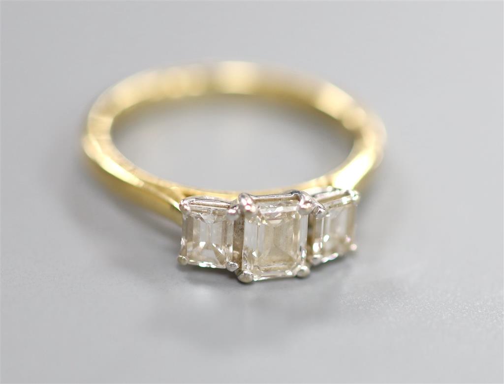 An emerald cut three-stone diamond ring, 18ct yellow and white gold setting, original box and receipt, size K, gross 3.3 grams.